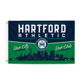 A Hartford Athletic flag featuring a navy blue top section with white lettering, a green bottom section with a dark navy skyline silhouette, and the team logo in the center.